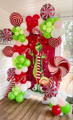 the grinch balloon arch is decorated with green, red and white candy canes