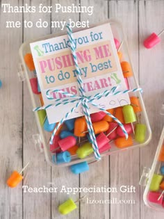 two small glass jars filled with candy on top of a wooden table next to a sign that says thank you for fishing me to do my best