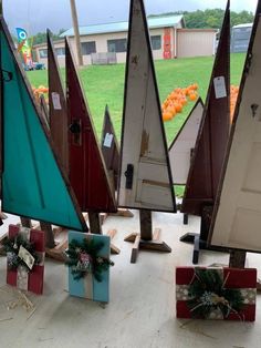 small sailboats are on display in front of a window with gifts tied to them