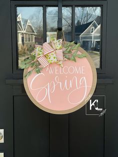 a welcome spring door hanger hanging on a front door