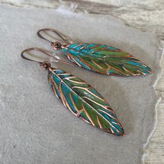 These hand painted artsy copper leaf earrings are a unique and striking accessory that have been crafted in our island studio using a special house patina paint blend resulting in a beautiful blue green finish reminiscent of the Caribbean sea. Once the patina process is complete, we buff and seal the copper for durability and to prevent tarnishing. Each pair of earrings are one-of-a-kind, with variations in the patina that add to their handmade charm. Size: 2.50 Inches from Lobe Ear Wire: Choice of Antique Copper or Sterling Silver French Ear Hooks with Safety Back Lightweight and Comfortable Handmade in the USA Gift Ready: Your earrings come in a gift pouch ready for giving or to treasure for yourself. Hand Painted Copper Bohemian Earrings, Bohemian Hand Painted Copper Earrings, Artistic Hand Painted Copper Earrings, Artsy Hand Painted Copper Jewelry, Hand Painted Copper Artsy Earrings, Hand Painted Artsy Copper Earrings, Green Hand Painted Copper Earrings, Artsy Hand Painted Copper Earrings, Hand Painted Green Copper Jewelry