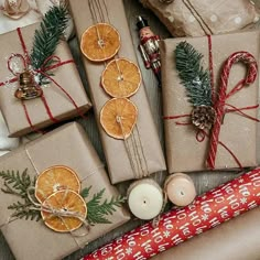 christmas presents wrapped in brown paper and tied with twine, pine cones, orange slices, cinnamons, fir tree branches