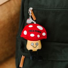 a mushroom keychain hanging from the back of a backpack