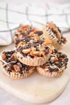 some kind of dessert that is sitting on a white plate with chocolate chips and nuts