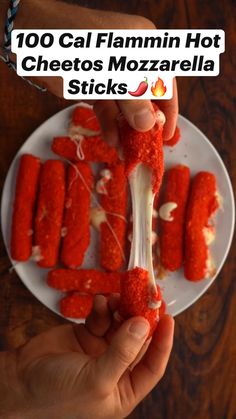 someone is holding up some food on a plate with the words, 100 cal flaming hot cheetos mozzarella sticks