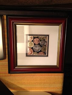 a bathroom with a sink, toilet and framed coins