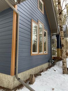 a blue house with wood trim and windows