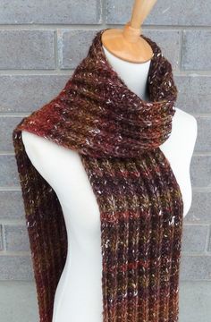 "This beautiful hand knitted scarf is made with high-quality yarn, which has tweed flecks and variegated colorways (95% Wool, 5% Silk). Classic ribbed pattern, it looks the same on both sides. The scarf can be worn in multiple ways. Very beautiful colors: shades of brown, olive, and burnt orange. The colors may appear slightly different on different monitors. Measures: 73\" (185 cm) long x 7\" (18 cm) wide. Although this yarn is soft and looks absolutely beautiful, it contains 95% of wool and mi Brown Knitted Scarves For Fall, Brown Fall Scarf, Brown Knitted Scarf, Casual Brown Knitted Scarf, One Size Brown Knitted Scarves, Hand Knitted Scarf, Chunky Knit Scarf, Scarf Chunky, Chunky Knit Scarves