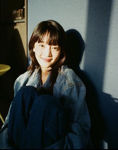 a woman sitting on the floor in front of a blue wall