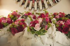 several bouquets of pink and red roses are on display in front of a mirror