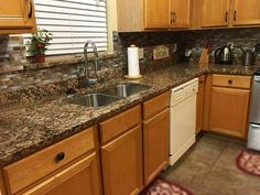 a kitchen with granite counter tops and stainless steel dishwasher, sink, and refrigerator