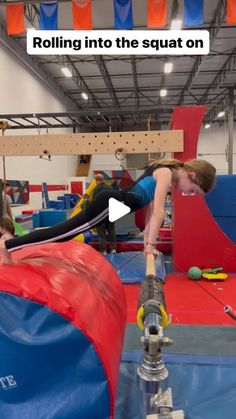 a woman is on a trampoline in an indoor gym