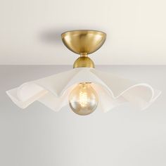 a light that is on top of a white ceiling fixture with a glass bulb in the middle