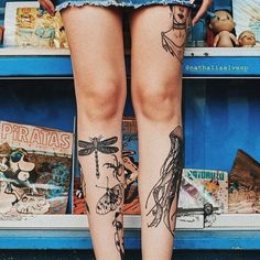 the legs of a woman with tattoos on them are standing in front of bookshelves