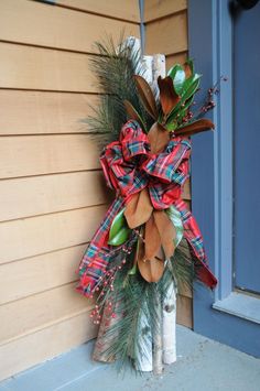 a christmas wreath hanging on the side of a house