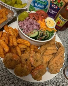 a white plate topped with fried food next to bottles of ketchup and sauce