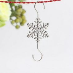 a snowflake ornament hanging from a red string