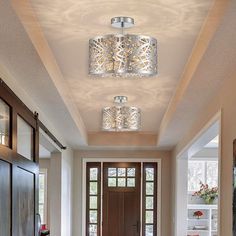 an entry way with two lights on the ceiling and a rug in front of it