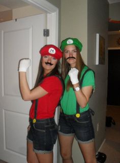 two women dressed up as mario and luigi in front of a door with their arms around each other