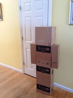 a stack of cardboard boxes sitting on top of a hard wood floor next to a door