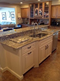 a kitchen with marble counter tops and stainless steel dishwasher in the center island