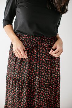 Looking for a little something floral this winter? The 'Arisha' Skirt is the perfect way to incorporate festive florals subtly. This gorgeous skirt features a tiered silhouette and smocked waistband to keep you comfortable all day. Pair the 'Arisha' with a simple top and sneakers for heading to that local market or grabbing brunch with friends! Self & Lining 100% Polyester Hand Wash Cold Do Not Bleach Lay Flat to Dry Low Iron if Needed Partially Lined FINAL SALE: NOT ELIGIBLE FOR RETURN OR EXCHA Fall Floral Print Relaxed Maxi Skirt, Dark Floral Maxi Skirt, Elegant Black Floral Print Maxi Skirt, Black Floral Print Midi Skirt, Black Floral Print Tiered Skirt, Simple Top, Floral Maxi Skirt, Floral Maxi, Smocking