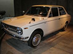 an old white car on display in a museum