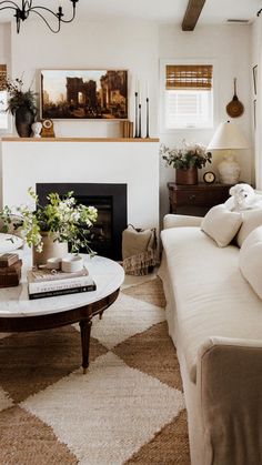 a living room filled with furniture and a fire place in front of a white fireplace