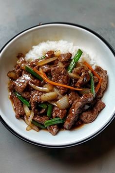 a white bowl filled with meat and vegetables