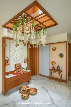 a room that has some plants hanging from the ceiling and two bowls on the floor