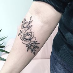 a black and white flower tattoo on the arm