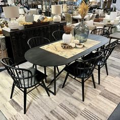 a room filled with lots of furniture and tables in front of a store display window