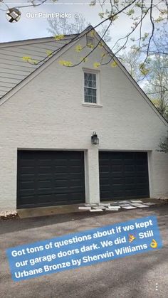 a white house with two garage doors on it