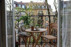 a small table and chairs on a balcony