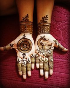 two hands with henna tattoos on them