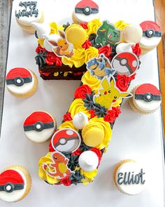 a birthday cake decorated with pokemon themed cupcakes