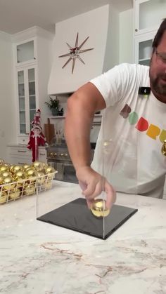 a man standing in front of a counter with some gold decorations on top of it