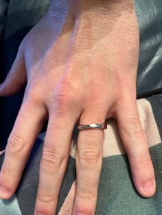 a close up of a person's hand with a ring on it