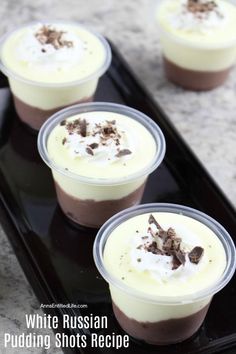 three dessert cups with white russian pudding in them on a black serving tray, topped with whipped cream and chocolate shavings