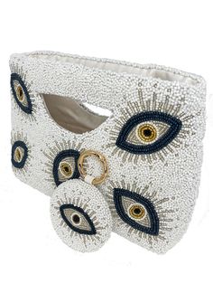 a white purse with blue and yellow eyes on it