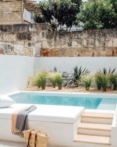 an outdoor swimming pool with steps leading up to it and a bag on the ground