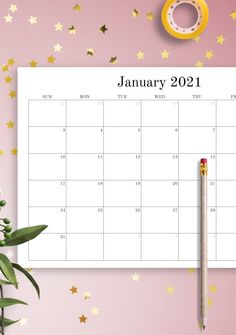 a calendar with a pencil on top of it next to some plants and gold stars