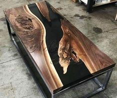 a coffee table made out of wood and metal frame with an artistic design on the top