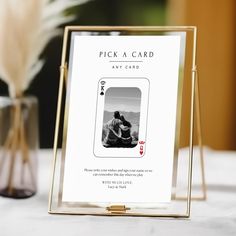 a table with a card holder on it and a vase in the background that says pick a card