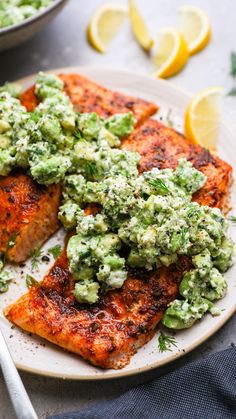 salmon with guacamole sauce and lemon wedges