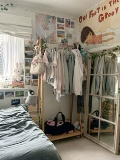 a bedroom with clothes hanging on the rack