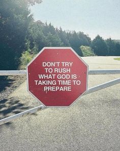 a red stop sign sitting on the side of a road next to a white fence