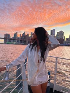 a woman standing on top of a boat near the water