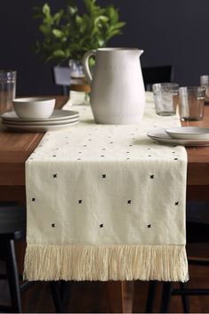 the table is set with white dishes and silverware, along with a star - patterned table runner