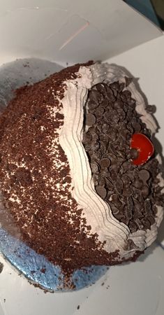 a chocolate cake with white frosting and oreo cookies on top is sitting in a box